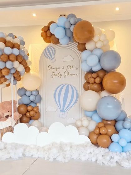 A wide shot of the hot air balloon baby shower, showing the full extent of the balloon clouds on the floor, creating a dreamy effect.