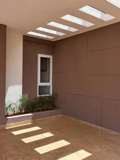 A simple yet powerful example of architectural design creating a play of light and shade. The strategic openings in this covered walkway cast geometric patterns on the floor, turning a simple passage into a dynamic experience.