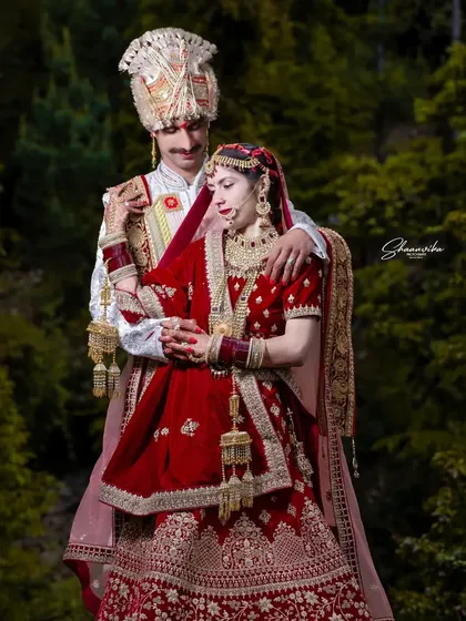 An intimate pose amidst nature. The lush green background makes the couple's connection the central focus of this romantic wedding photograph.