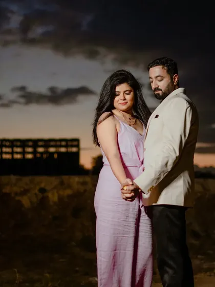 A moody and romantic shot at dusk. The dramatic sky and the couple's close embrace create a powerful and emotional pre-wedding photograph.
