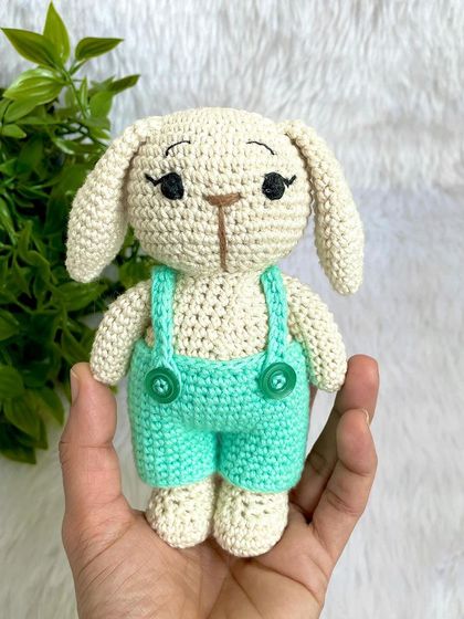 This handsome boy bunny wears a cute pair of sea-green dungarees. His long eyelashes give him such a sweet and gentle expression.