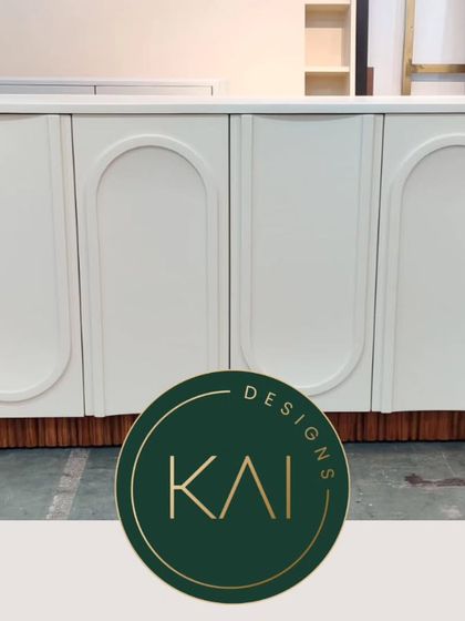 A workshop view of the white arched-door cabinet, showcasing its form and construction.