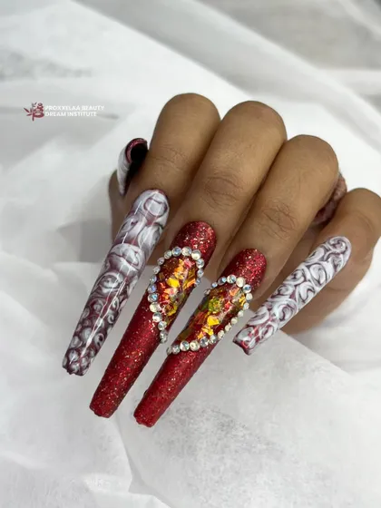 An extravagant design featuring full-coverage red glitter nails with a large, crystal-encrusted heart centerpiece, paired with intricate white and red marbled accent nails.
