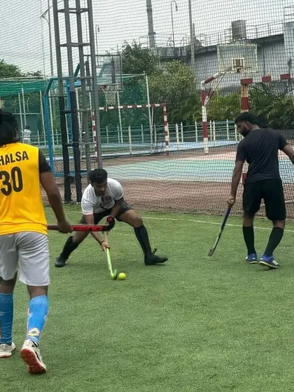 Three players converge on the ball in a tight contest for possession. Our practices are competitive and push everyone to improve.