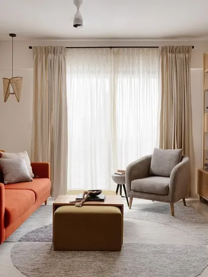 This living room is a perfect example of a 'Soulful Sanctuary'. I used a warm burnt orange sofa, an olive green ottoman, and a mix of textures to create a comfortable and practical open-plan space that feels both stylish and deeply inviting for the entire family.