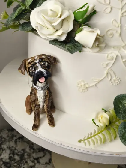 The second dog figurine from the wedding cake, a boxer with a happy, tongue-out expression. These personal touches are what make a wedding cake unforgettable.