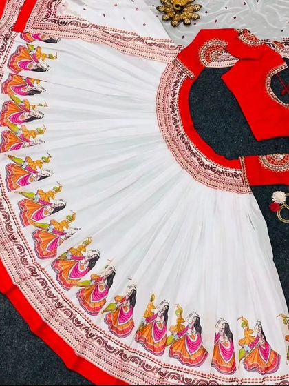 A flat-lay view of the dancer-print chaniya choli, showing the full circumference of the skirt and the matching red blouse. This view highlights the detailed print work along the border.