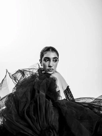 A thoughtful, off-camera gaze gives this monochrome portrait a sense of story and elegance. The flowing black tulle frames the model beautifully, and the soft lighting sculpts her features.
