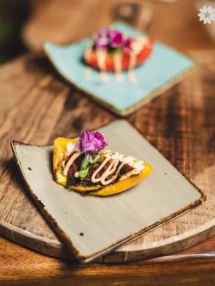 A modern presentation of a classic dish, served on a bed of roasted peppers. The vibrant colours and careful placement of each element demonstrate our commitment to culinary artistry.