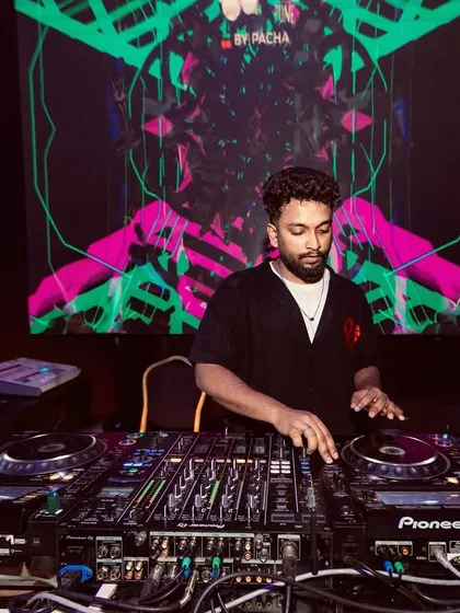 A close-up of me at the Pioneer decks against a vibrant visual backdrop. My focus is always on the technical side of the mix to ensure a flawless performance.