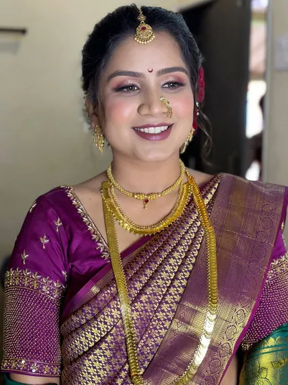 A happy Maharashtrian bride, with glowing makeup, a traditional nath, and a beautiful smile.