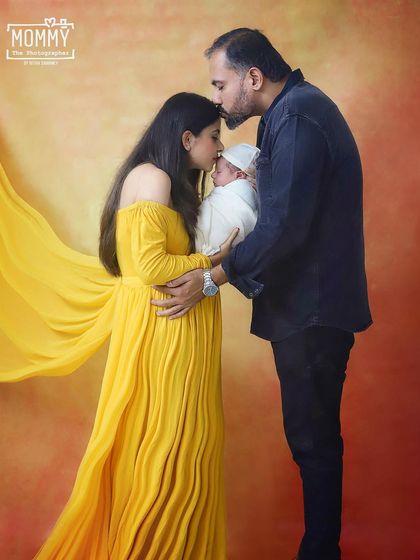 A kiss of love for their new baby. This tender moment between new parents, both kissing their newborn's head, is what family photography is all about.