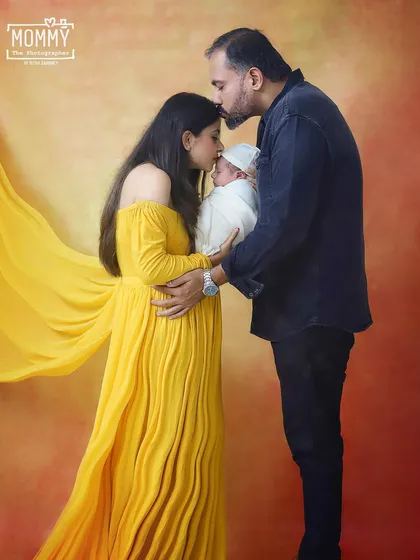 A kiss of love for the newest family member. This tender moment between parents and their newborn is what family photography is all about. The warm studio lighting adds to the loving atmosphere.