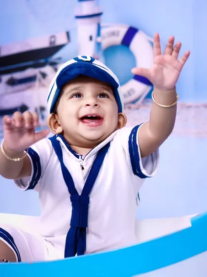 A close-up of a very happy little sailor, waving his hands with excitement.