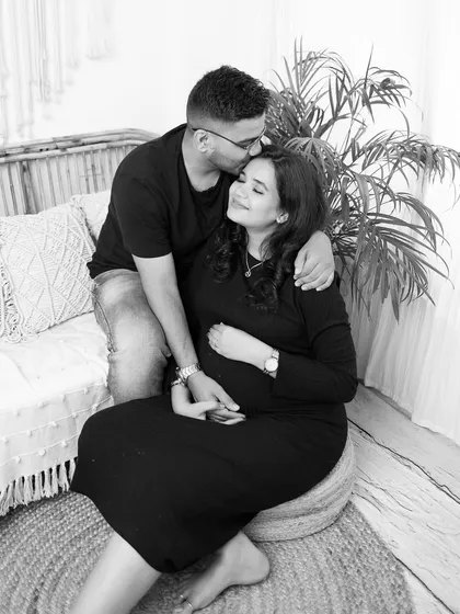 An intimate moment from an indoor boho maternity session. A gentle kiss on the forehead in this black and white portrait creates a feeling of warmth and tenderness.