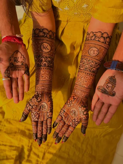 A full view of the couple's engagement mehendi. The coordinated designs, with the bride's intricate patterns and the groom's minimal motifs, look beautiful together.