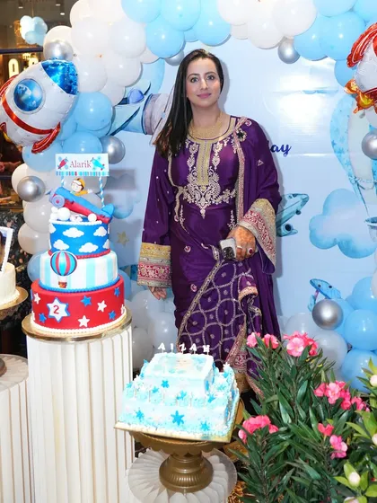 The birthday setup with the stunning tiered cake. Our balloon decoration served as the perfect backdrop for the cake cutting ceremony.