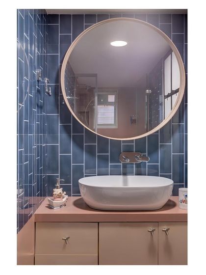 A second bathroom from the same Mumbai project, this time using deep blue subway tiles and a contrasting blush vanity to create a playful yet sophisticated atmosphere.