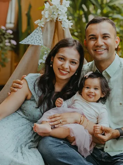 Celebrating six months is a milestone too. This sweet family portrait captures the joy of being halfway to one, set against a lovely green backdrop on their terrace.