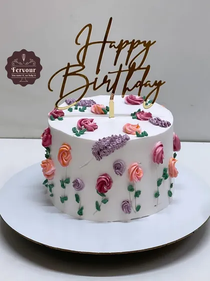 A vanilla truffle cake decorated with delicate, hand-piped flowers. This simple design is perfect for someone who appreciates understated elegance.
