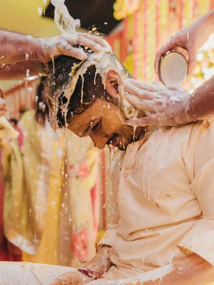 A close up of the groom during the 'doodh haldi' ritual, where he is showered with milk as part of the ceremony.