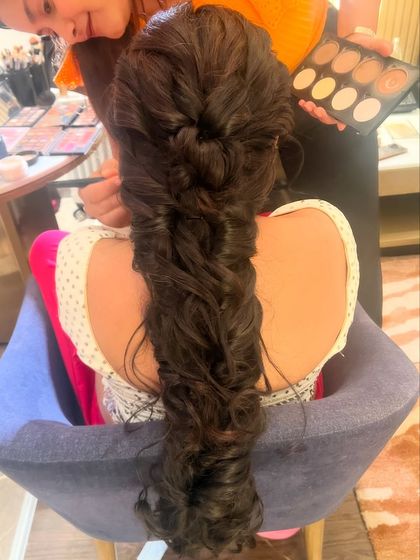A behind the scenes shot of a messy fishtail braid being created. This style is all about texture and volume.