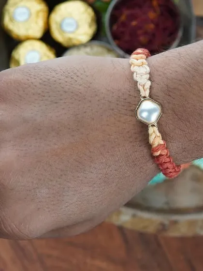 The Kundan Rakhi being worn on the wrist. It's designed to be comfortable and stylish.