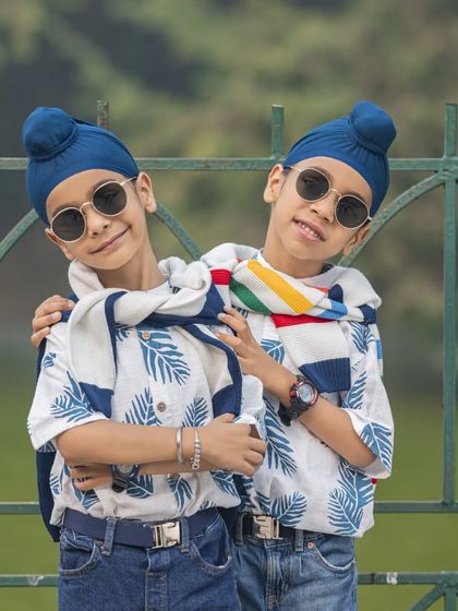 Double the fun, double the style! These two brothers are rocking their matching outfits and cool sunglasses in this fun outdoor portrait.