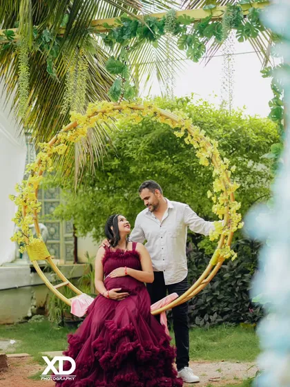 A romantic portrait of a couple on a circular swing adorned with yellow flowers.