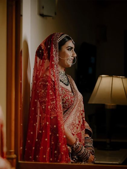A reflective bridal portrait, capturing the bride looking into a mirror. These quiet, candid moments during the getting-ready process are just as important as the main event.
