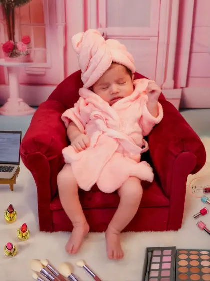 A fun and creative spa-day theme for a newborn. This little one is relaxing in her mini robe and armchair, surrounded by tiny makeup props.