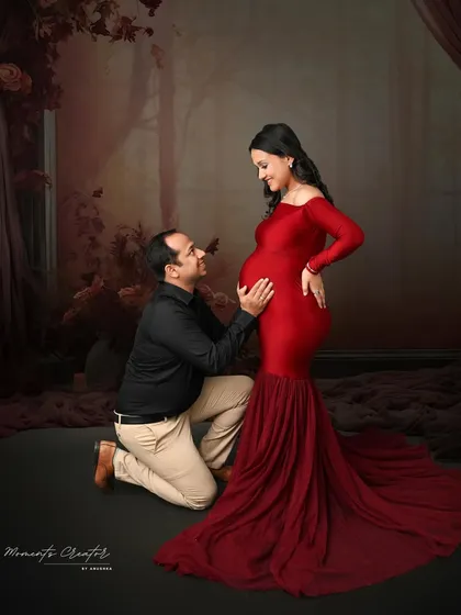 The dad-to-be lovingly cradles the baby bump. I guide couples into poses that feel natural and highlight their connection, like this tender moment in a dramatic red gown.