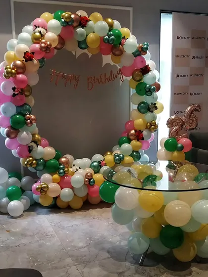 A vibrant and colorful ring decoration for a 26th birthday. We used a mix of pastel balloons in multiple colors to create a full and festive look, complete with a balloon-decorated table for the cake.