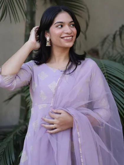 A candid and happy portrait, capturing a natural smile and the soft, elegant drape of a pastel lavender suit.