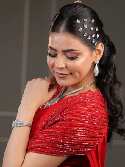 A final, graceful pose in the red saree. This image captures the elegance and confidence that comes with a perfect makeup look.