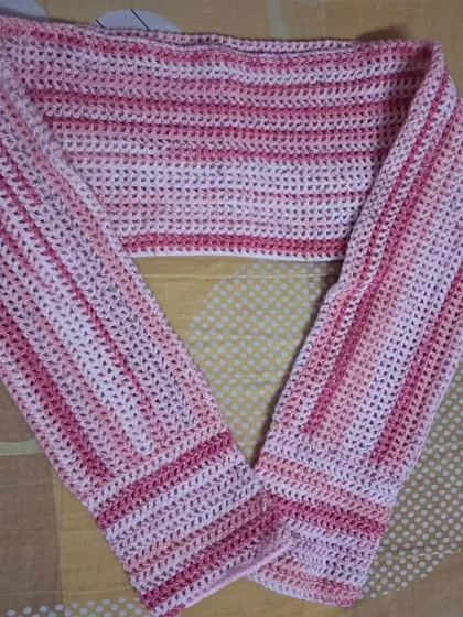 A flat-lay of the pink mesh bolero, showing the full construction from sleeve to sleeve.