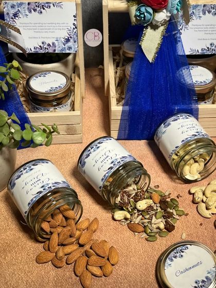 Shop for your wedding return favours with us. This beautiful set includes a pinewood basket with a succulent plant and three jars filled with almonds, cashews, and healthy mixed seeds.