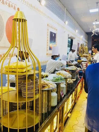 My chefs are the heart of the service, and the buffet line is their stage. This image captures my team in action, serving guests from a beautifully arranged and well-lit premium counter.