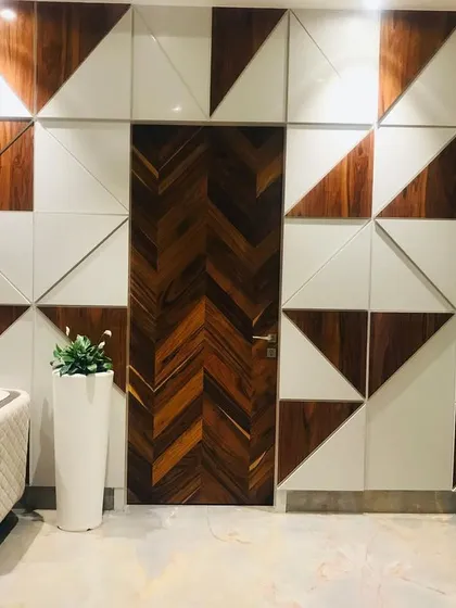A unique feature wall I designed for an office in Faridabad. The geometric pattern, created using a mix of wood and white panels, conceals a door, blending it seamlessly into the wall for a clean and artistic look.