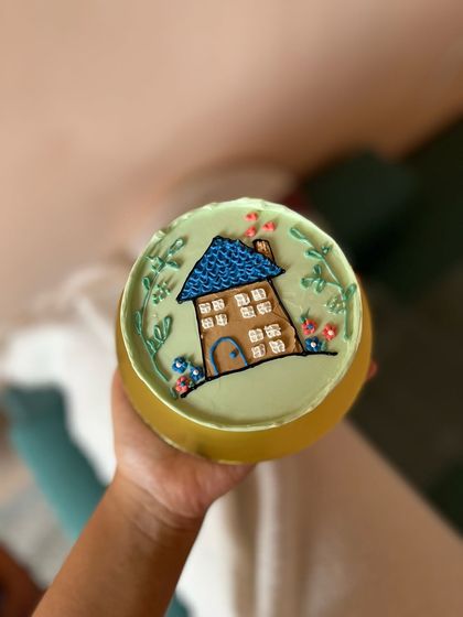 This bento cake features a cozy little house hand-piped with buttercream. It's a sweet and simple design that feels like home.