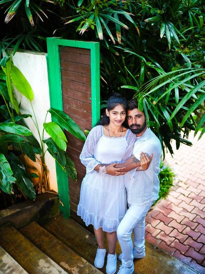 A couple embraces in a lush green corner of the garden, a perfect intimate shot.