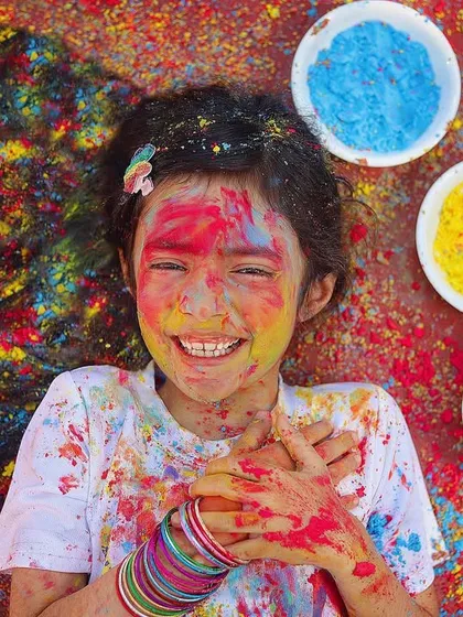The pure joy of Holi! This older child is having a blast, covered in bright colours. These sessions are so much fun and capture the true spirit of the festival.