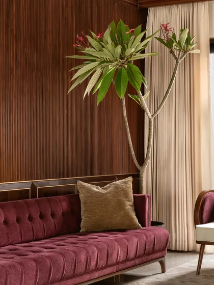 The deep tufting on this custom magenta velvet sofa adds a layer of classic luxury, contrasted with the modern wood-paneled wall. We believe in mixing styles to create a space that feels intentional and deeply personal.