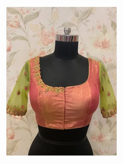 The front of the pink and green blouse, featuring a simple square neckline and sheer embroidered sleeves.