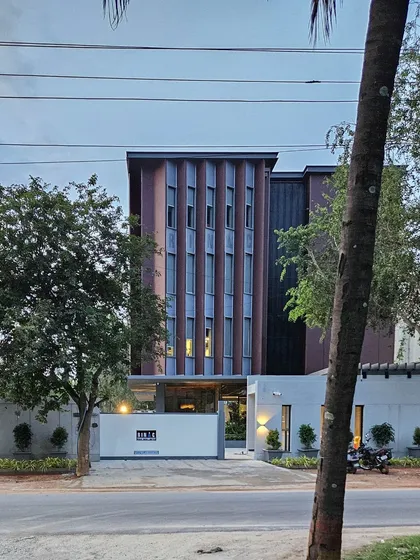 A view of the RINAC HQ building from the street, showcasing the modern architectural facade. The design balances solid massing with vertical window arrangements to create a distinctive and professional corporate presence.