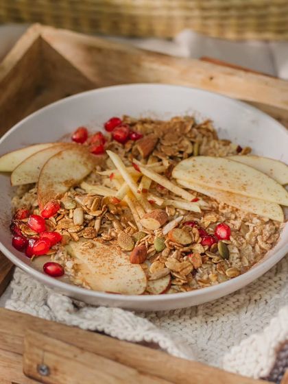 A cozy bowl of our apple overnight oats, topped with fresh apple slices, pomegranate, and a sprinkle of cinnamon. It’s a comforting and healthy treat, perfect for breakfast in bed.