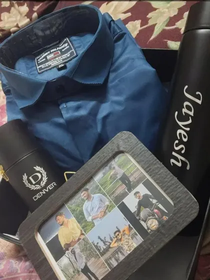 This gift hamper includes a personalized photo frame, a name-engraved temperature bottle, a shirt, and deodorant, making it a truly personal and memorable present.