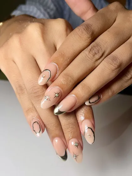Shine bright with these stunning chrome nails. This set features abstract chrome shapes, star details, and a delicate chrome French tip for a truly unique look.