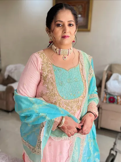 A beautiful and elegant look for a wedding guest. The soft pink and turquoise outfit is paired with a subtle makeup look and a neat updo, perfect for a day ceremony.