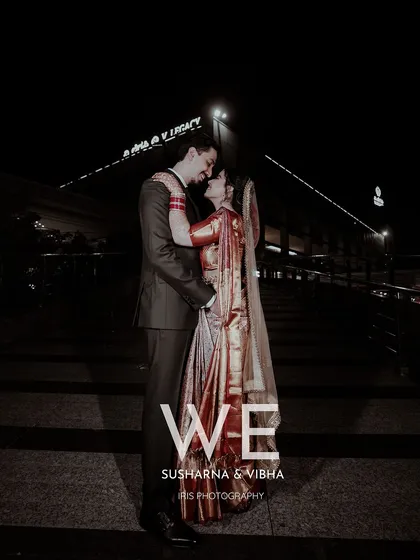 A dramatic night time portrait of the couple. The city lights in the background add a modern, urban feel to this romantic wedding photo.